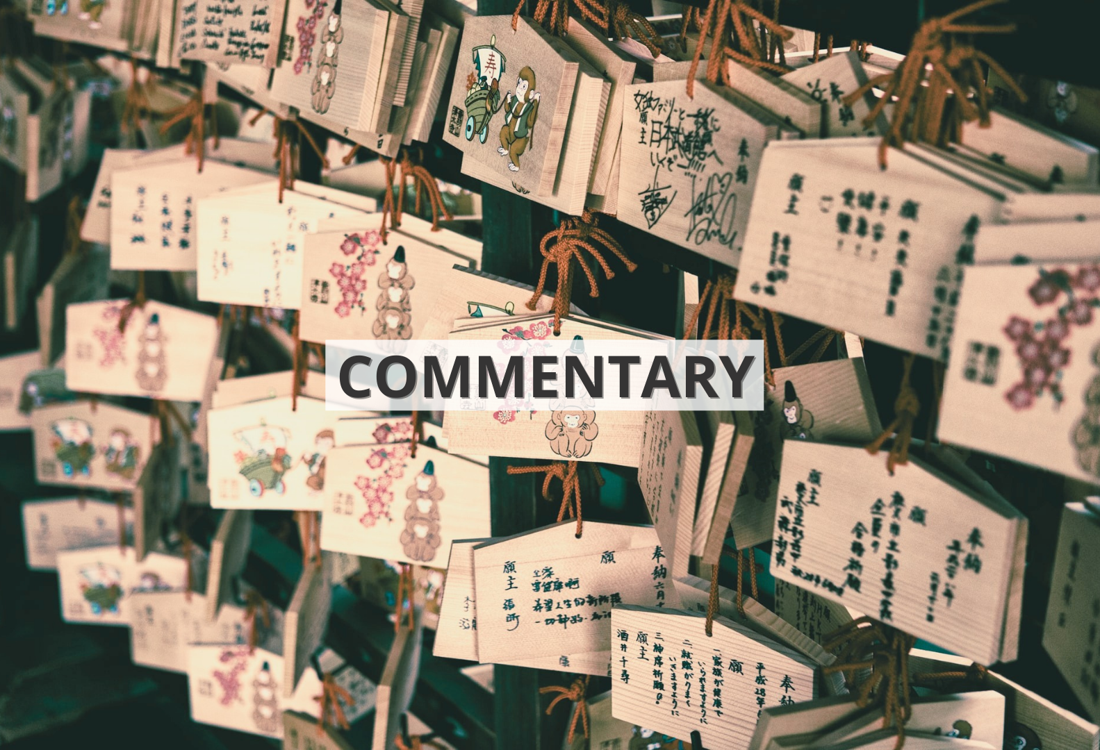 [Translate to English:] Drewniane tabliczki z życzeniami zapisanymi chińskimi znakami wiszące we wschodnioazjatyckiej świątyni z napisem ‘commentary’ / Wooden signs with wishes written in Chinese characters hanging in an East Asian temple with the inscription 'commentary'