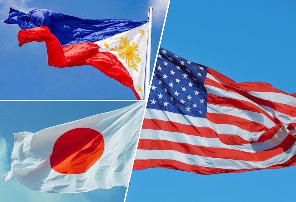 W lewym górnym rogu flaga Filipin, w lewym dolnym rogu flaga Japonii, a po prawej stronie flaga USA