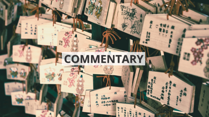 [Translate to English:] Drewniane tabliczki z życzeniami zapisanymi chińskimi znakami wiszące we wschodnioazjatyckiej świątyni z napisem ‘commentary’ / Wooden signs with wishes written in Chinese characters hanging in an East Asian temple with the inscription 'commentary'