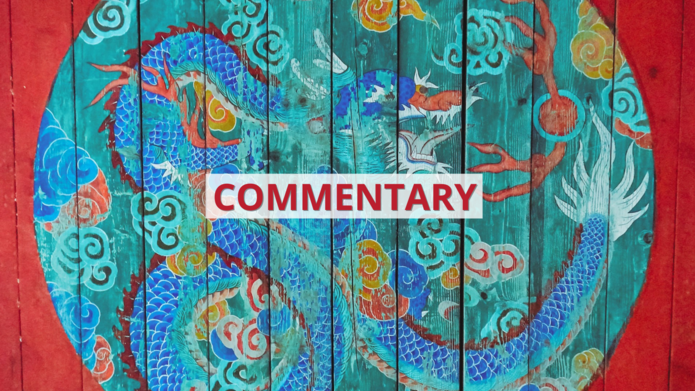 Namalowany na czerwonym drewnie wielobarwny okrąg ze smokiem we wschodnioazjatyckim stylu z napisem ‘commentary’ / A multicolored circle with a dragon painted on red wood in East Asian style with the inscription 'commentary'