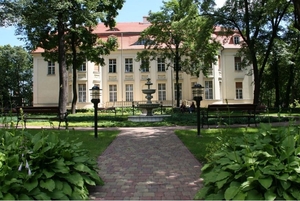 Fontanna z pałacem w tle w otoczeniu drzew/A fountain with the palace in the background, surrounded by trees